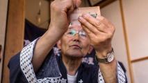 A japanese man is holding up a piece of paper.