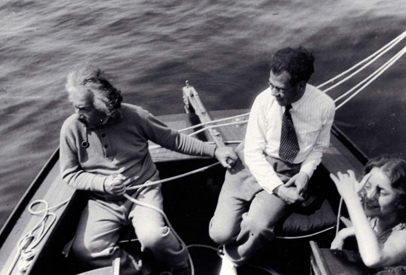 Three people sitting on a boat in the water.