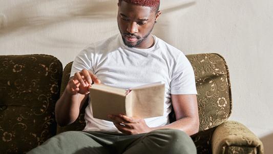 A man speed reading on a couch.