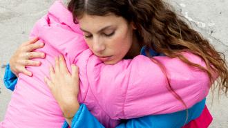 A woman hugging a woman in a pink jacket.