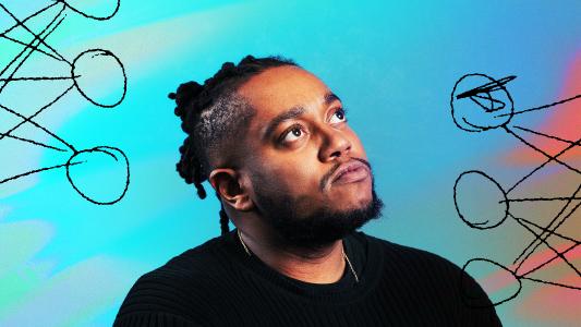 A man with dreadlocks in front of a vibrant background.