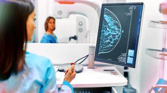 a woman getting a mammogram while another one performs the screening