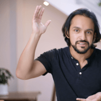 A man in a black shirt is waving his hand in the air.